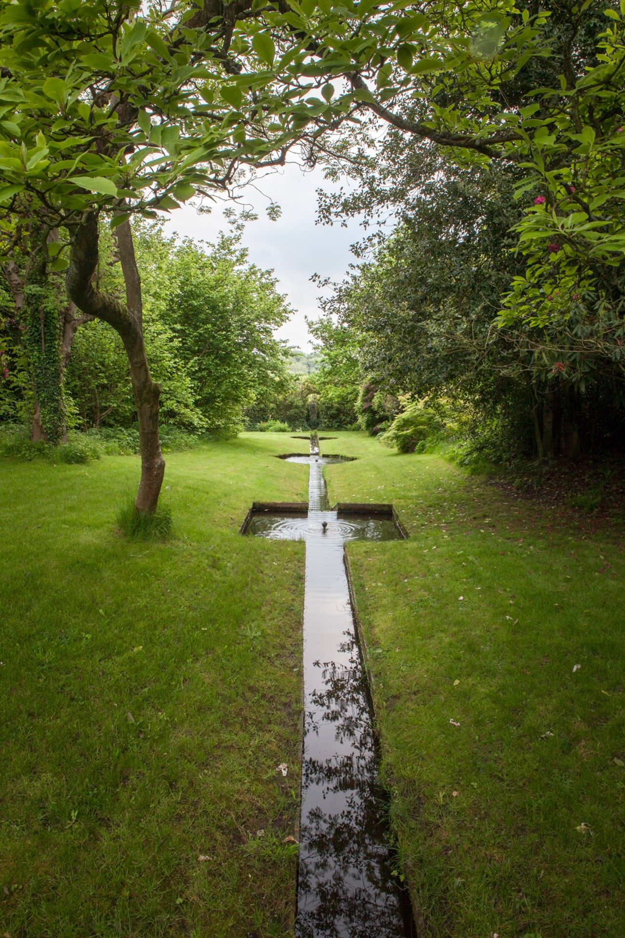 Image may contain Cross Symbol Grass Plant Ditch Path Green and Tree