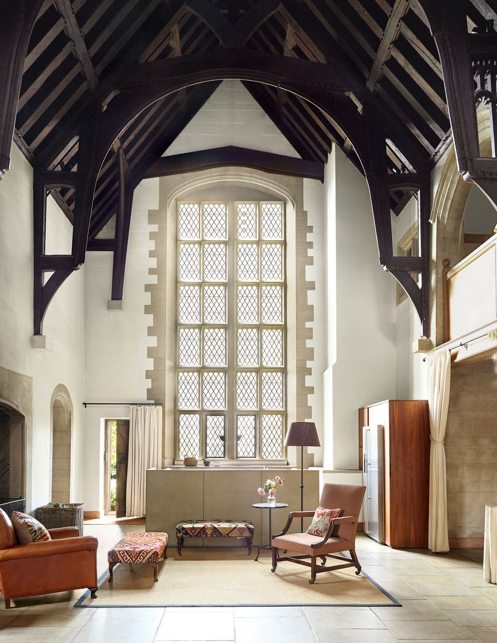 In the area between the kitchen and the dining table a leatherupholstered club chair faces a George III armchair...