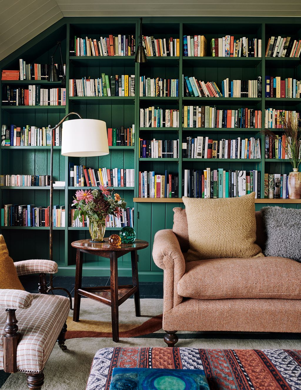 Image may contain Furniture Bookcase Indoors Room Living Room Rug Library and Book