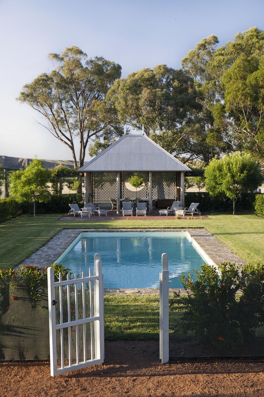 The pool pavilion is in the Australian vernacular style with a pitched corrugatediron roof.