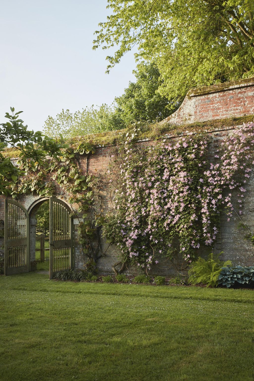 Leading into the orchard wooden gates crafted on the estate are set into an eighteenthcentury wall covered in cascades...