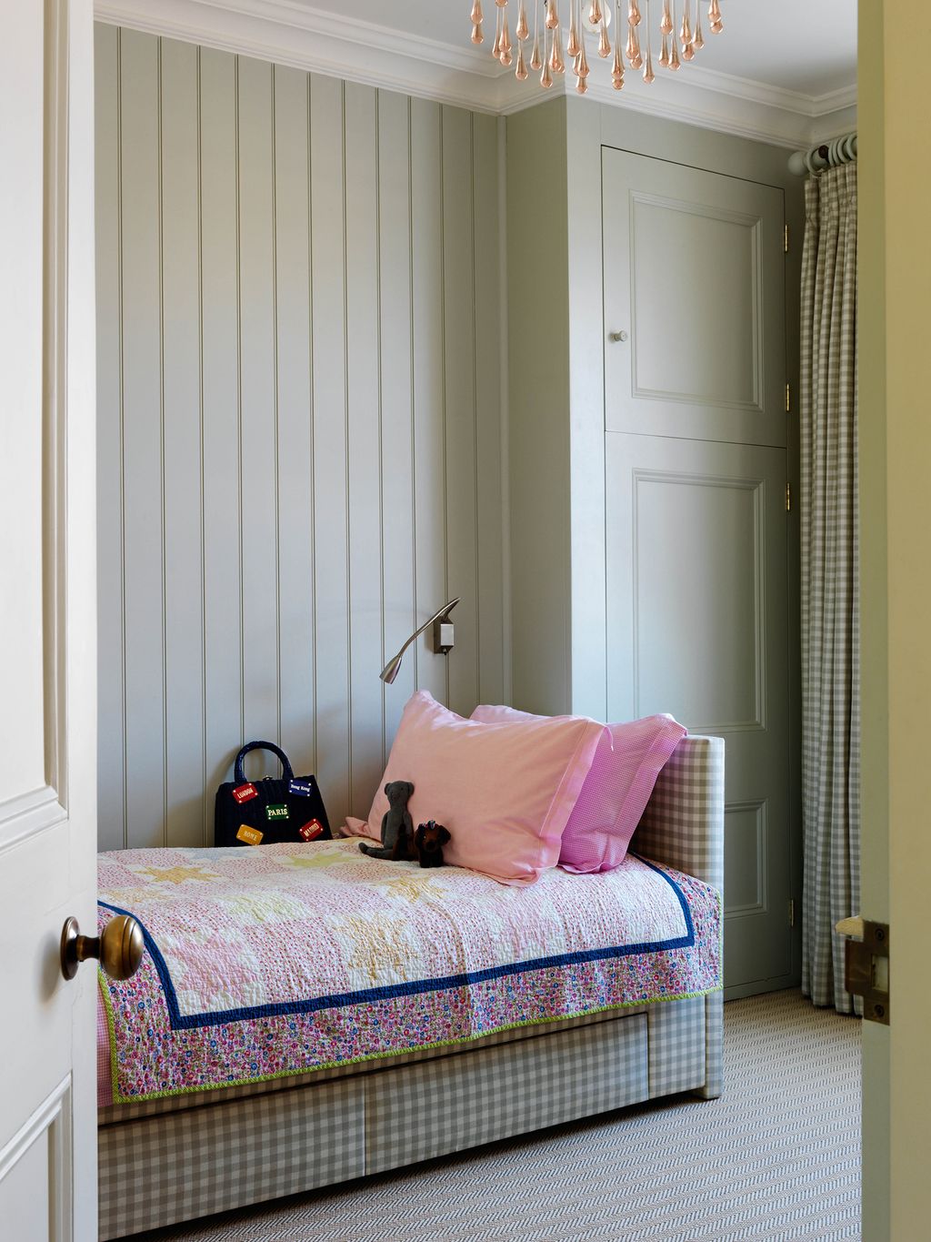 In the daughter's bedroom the check curtains and upholstered bed are in 'Small Check Sea Mist' fabric from Chelsea Textiles.