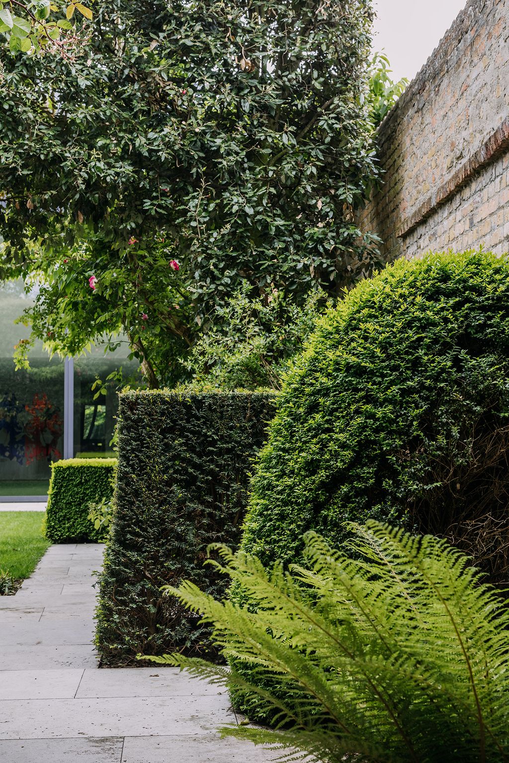 The area adjacent to the modern glassfronted building is more contemporary in feel with yew hedges clipped in strong...
