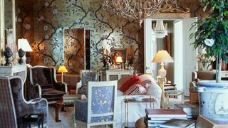 Image may contain Living Room Room Indoors Furniture Lamp Table Lamp Chair Couch Interior Design and Chandelier