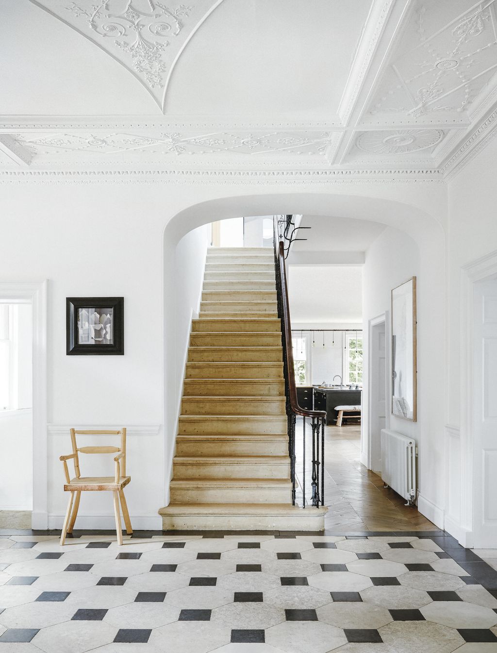 The crisp lines of the ceiling plasterwork are emphasised by an offwhite shade. A chair made by the couples daughter...