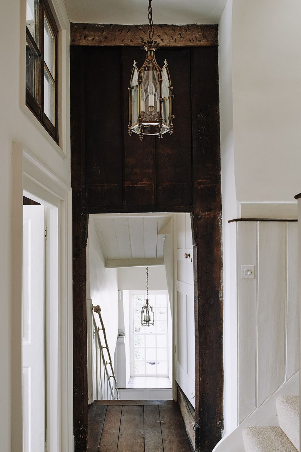 A corridor with a black and white scheme and a lantern light.