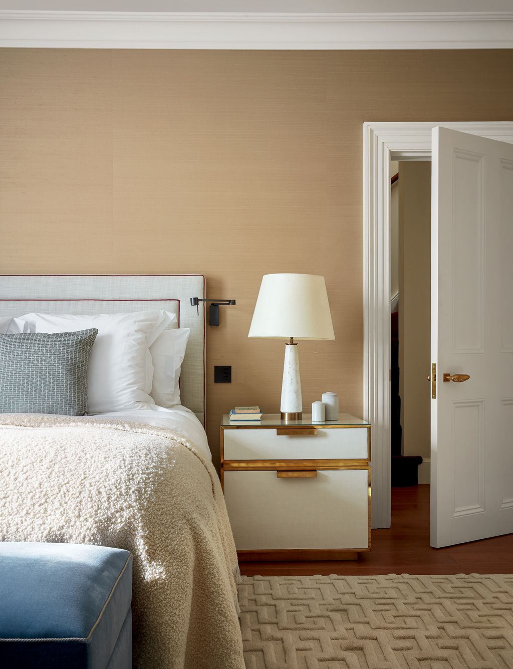 In the main bedroom the headboard is upholstered in Jane Churchills ‘Rostra fabric in the bone colourway with red rope...