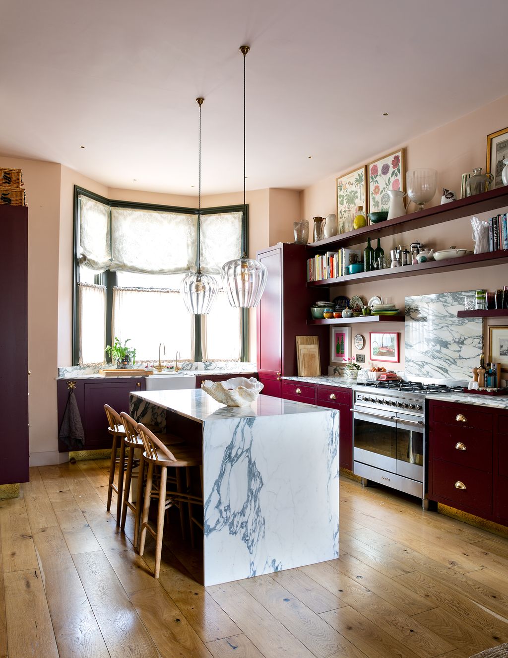 Designer Angelica Squires own house employs shelving in the same deep red colour as the joinery around it with a...