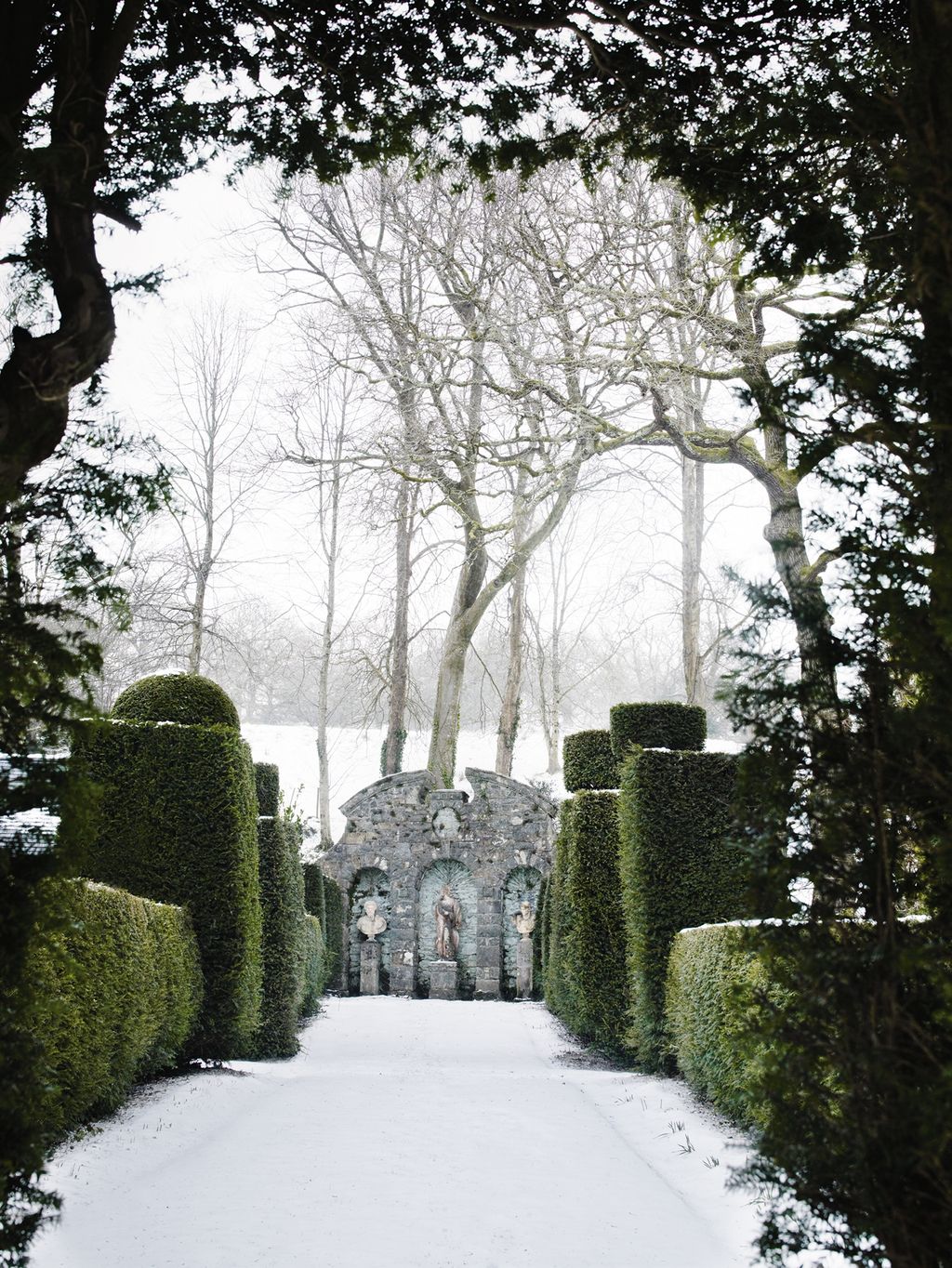 A trio of statues set in faded bluewashed alcoves in the boundary wall creates a striking focal point.