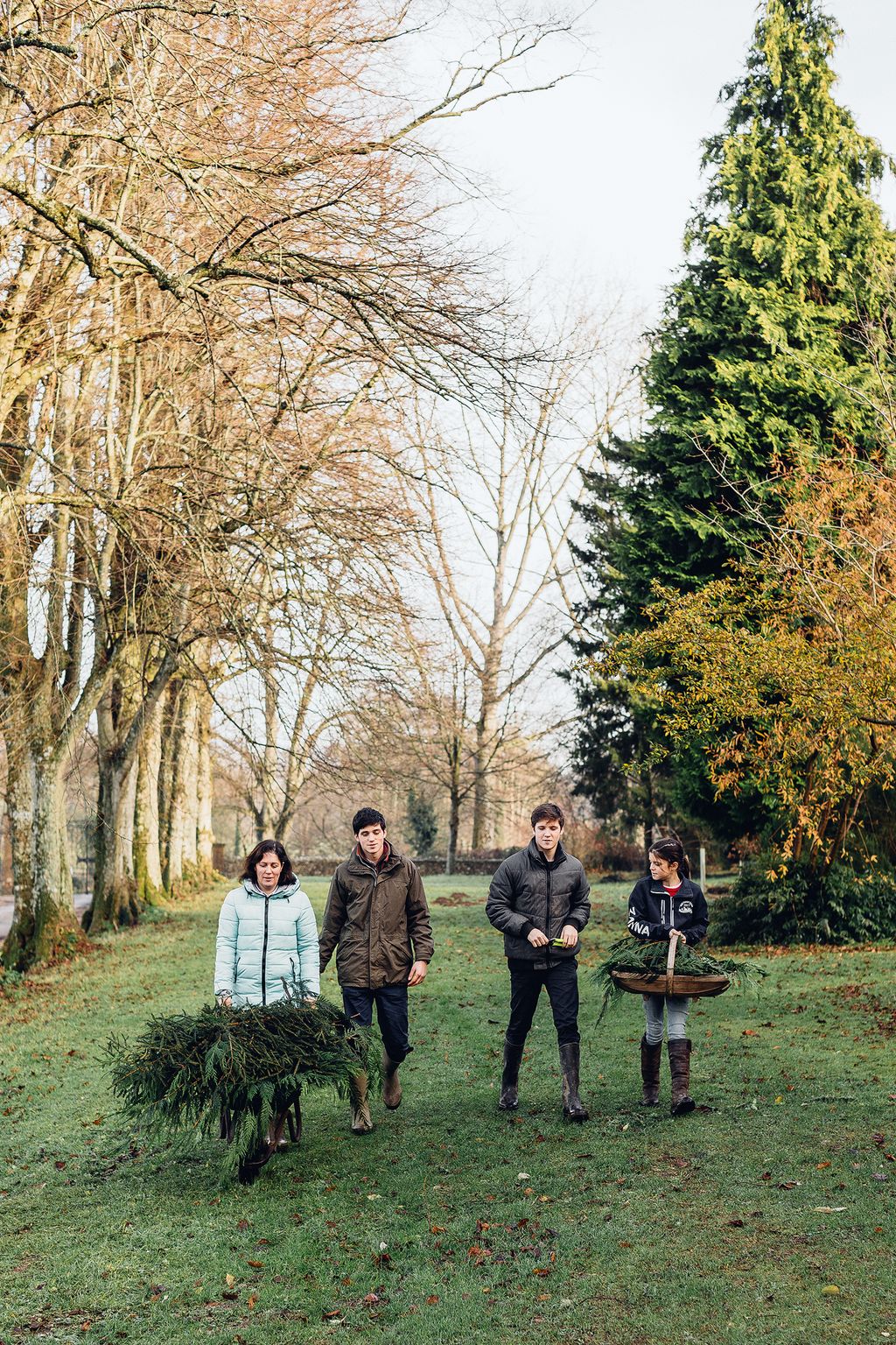 Image may contain Tree Plant Human Person Clothing Apparel Tree Trunk Grass and Coat