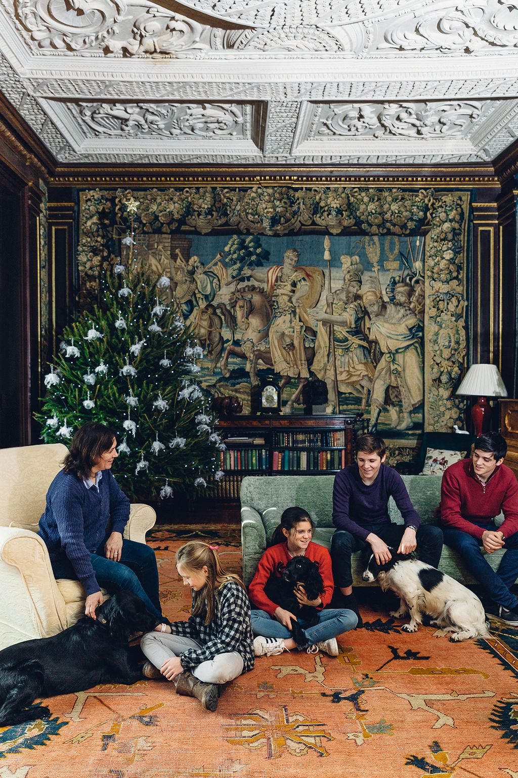 Image may contain Furniture Couch Human Person Living Room Room Indoors Animal Dog Mammal Pet Canine and Tree