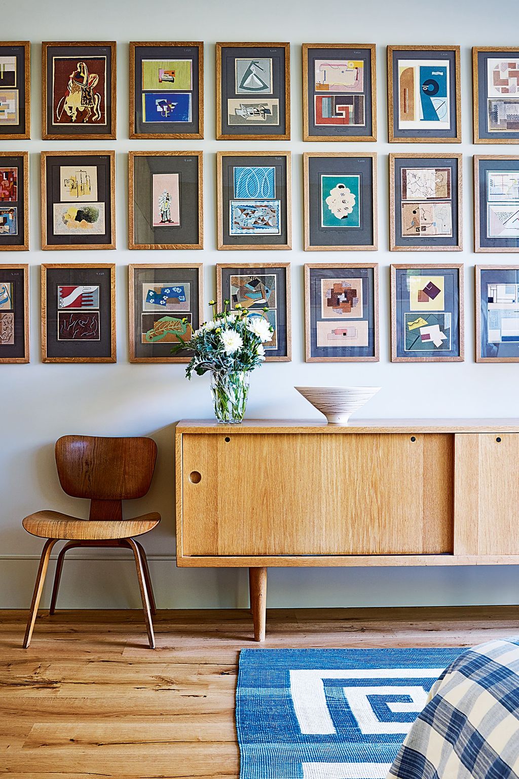 Modernist pieces including a Charles Eames side chair and a Hans Wegner sideboard and a geometric rug bought from Robert...
