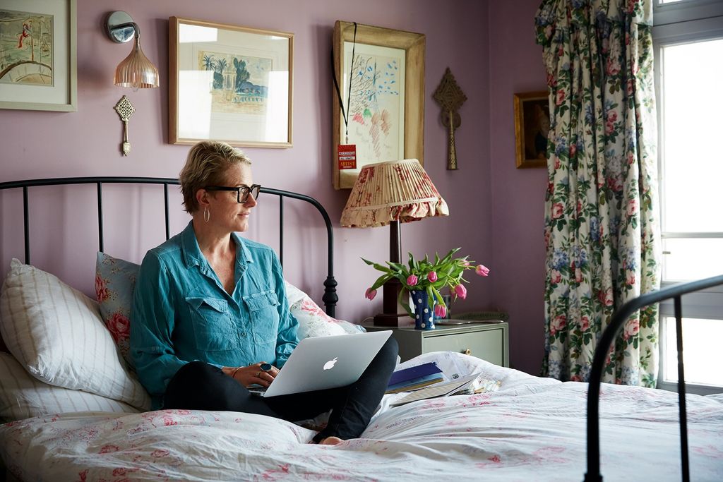 Researching fabrics and textiles in her bedroom the walls are decorated with Ethiopian crosses and a light from Heal's.