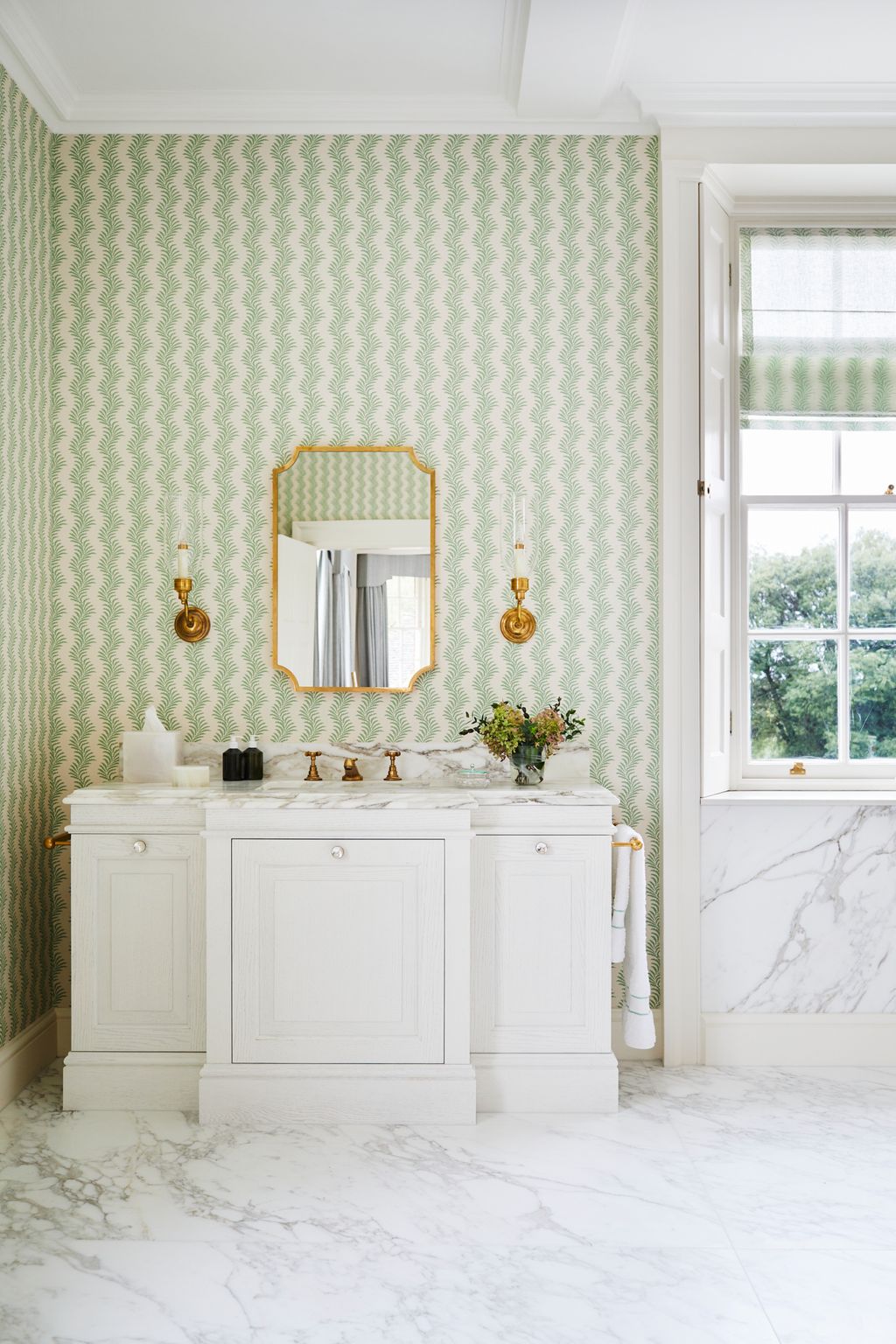 ‘Scrolling Fern Frond wallpaper in emerald from Soane was combined with Calacatta Oro marble flooring from Cullifords...