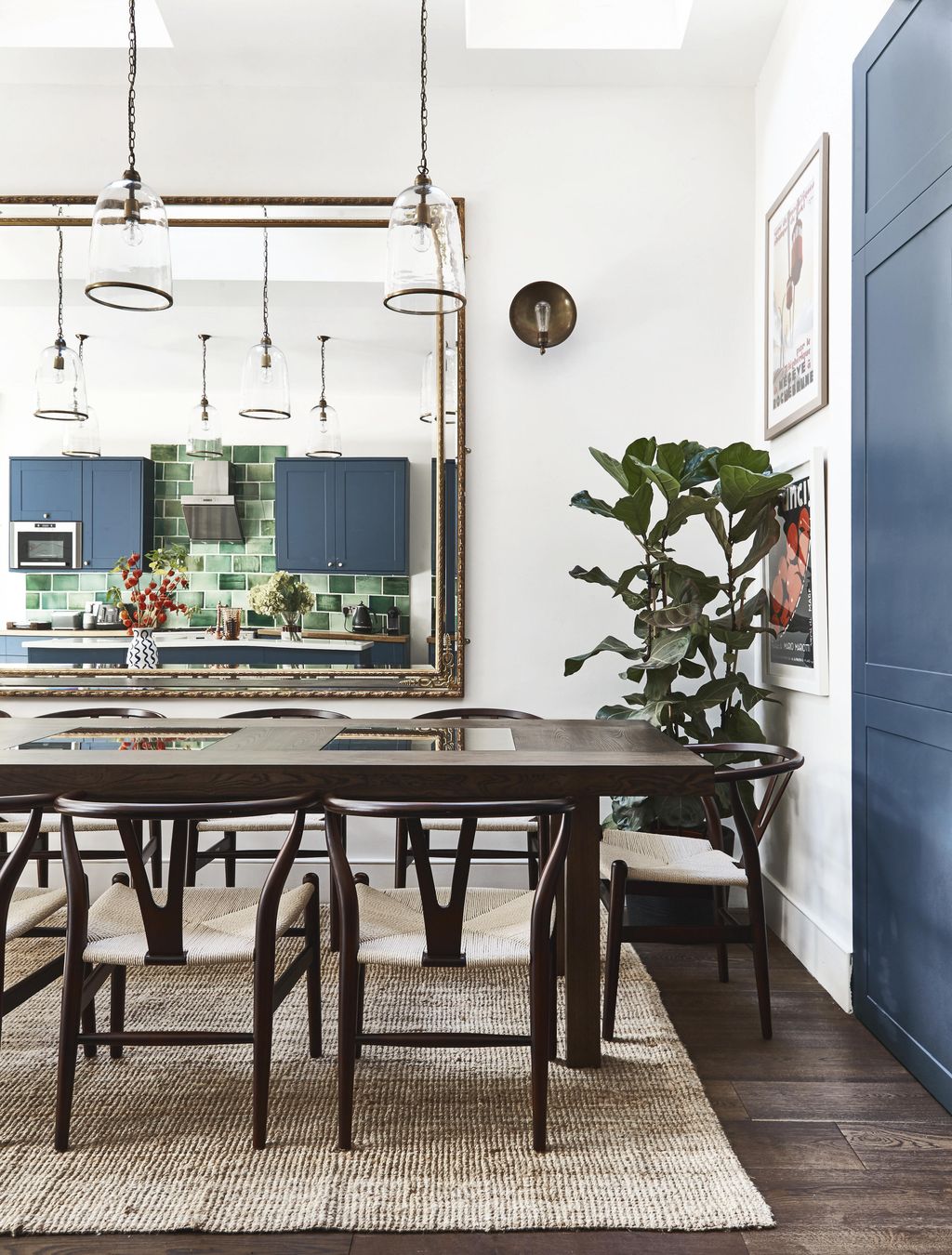 The dining table made by Ines Cole from upcycled wood is teamed with Wishbonestyle chairs from Cult Furniture. An...