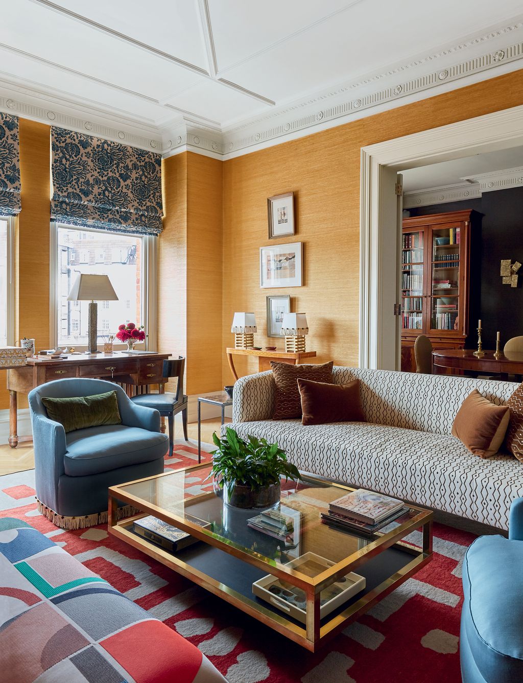 Grasscloth walls provide a rich backdrop for the ‘Eltham sofa by Ensemblier in Le Manachs ‘Zanzibar. Victorias ‘Table...