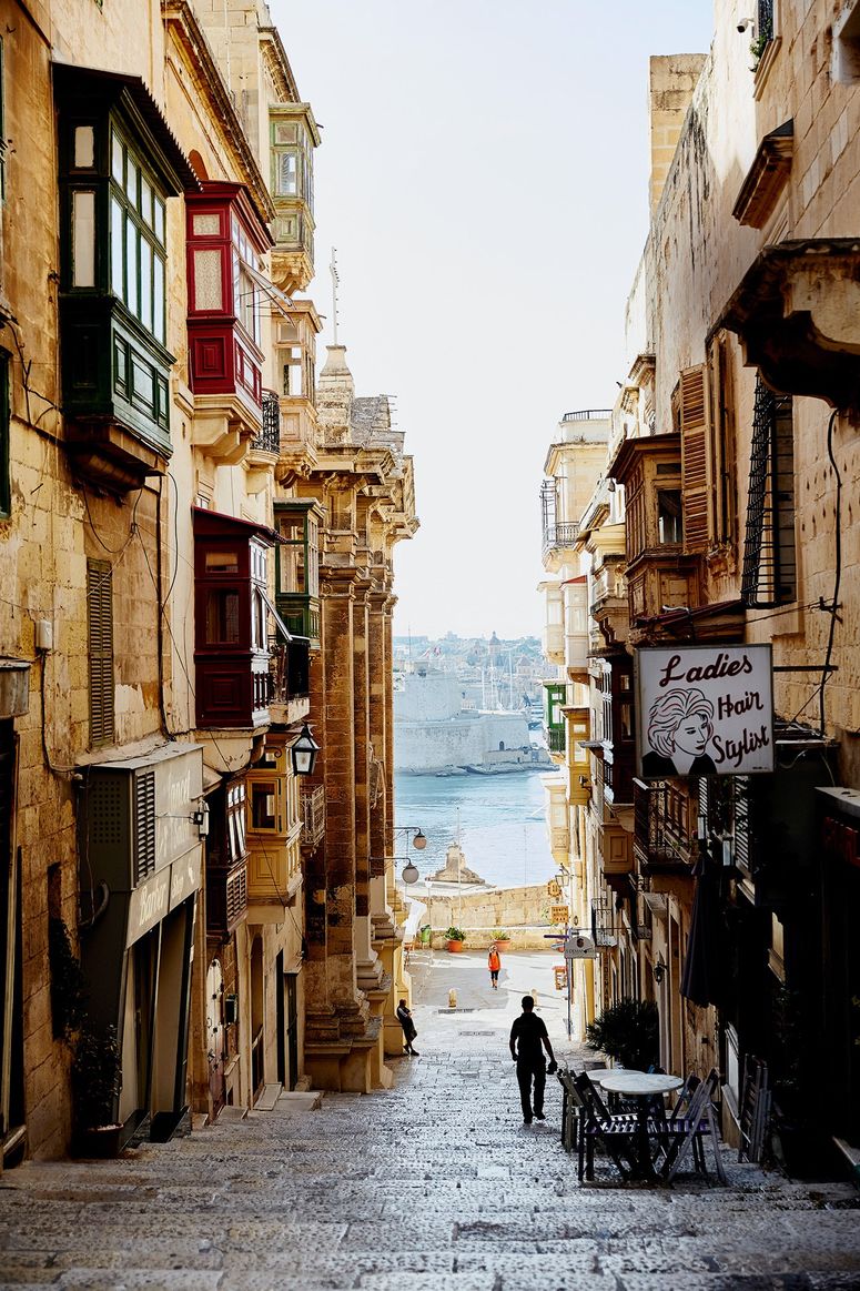 Image may contain: Human, Person, Path, Walkway, Pedestrian, Home Decor, City, Urban, Road, Town, Street, and Building