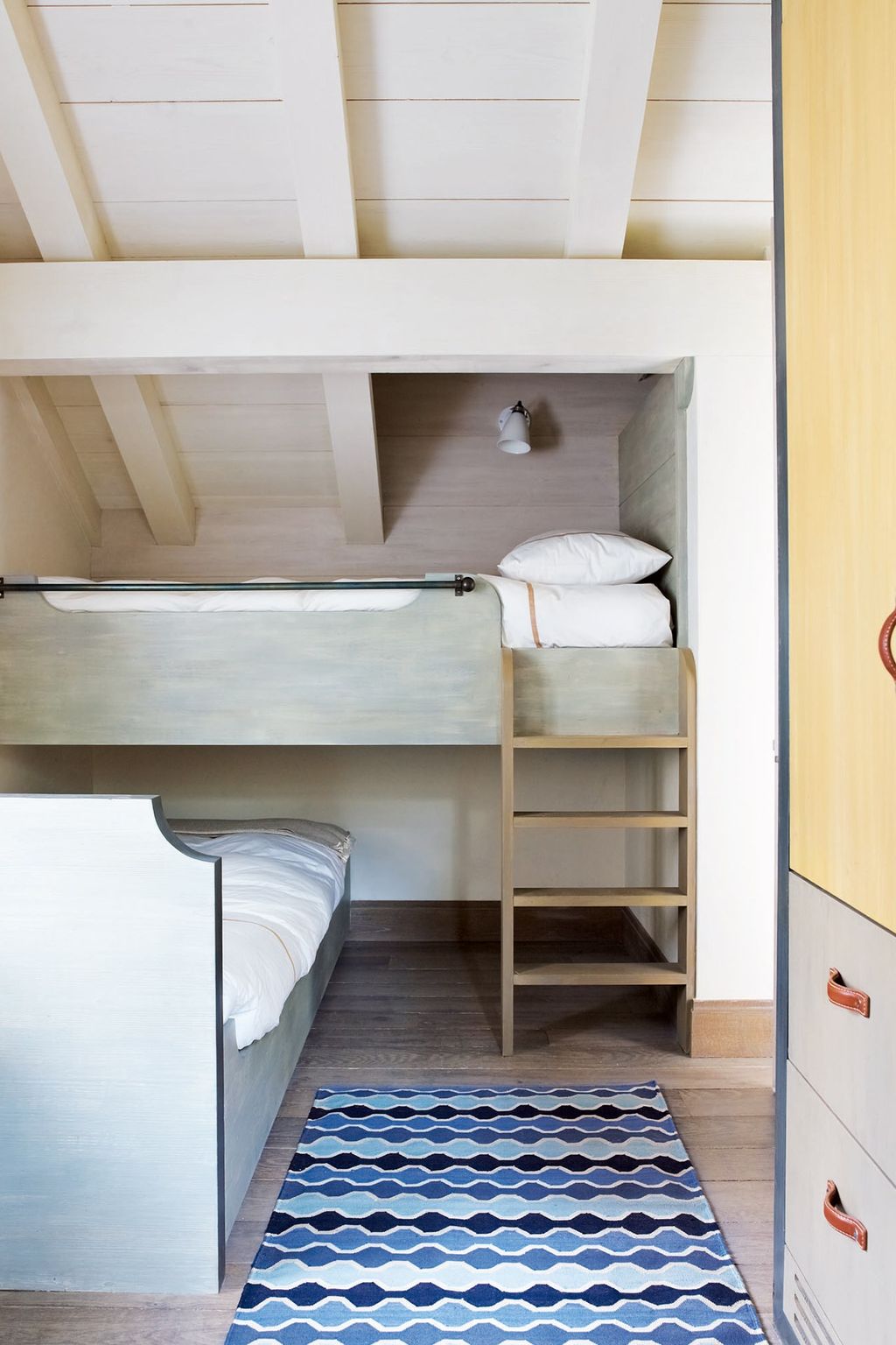 Image may contain Furniture Housing Building Rug Room Bedroom Indoors Bed Bunk Bed Hostel and Dorm Room