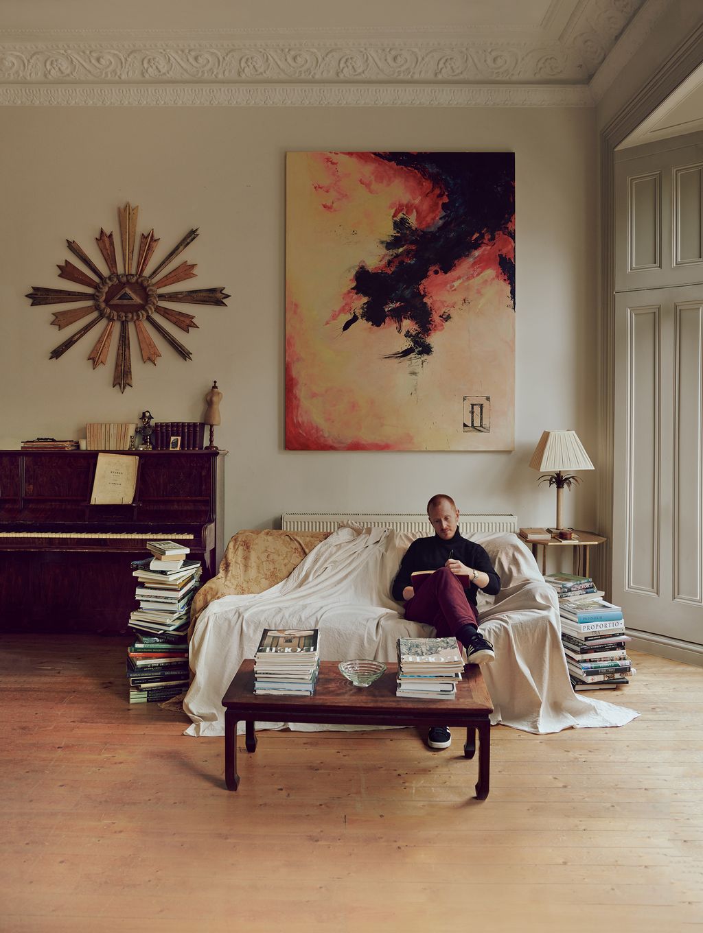 John in the sitting room of his London flat in which an 18thcentury Italian altarpiece hangs beside a painting by De...
