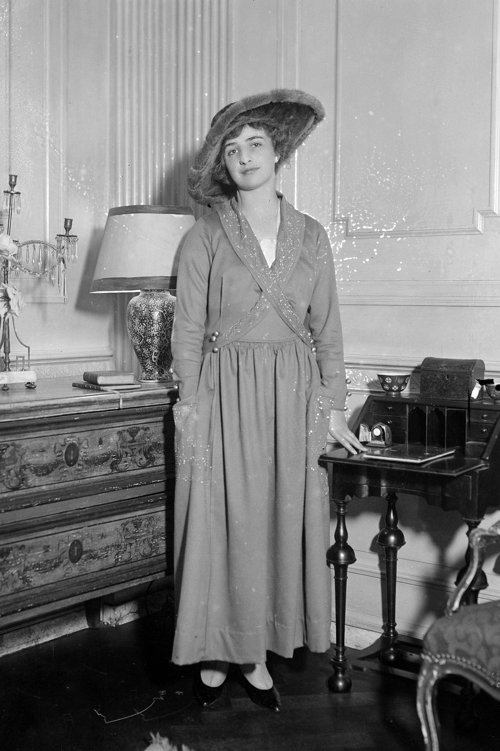 Image may contain Coat Clothing Apparel Dress Furniture Human Person Sleeve Hat Lamp Table Lamp Indoors and Room