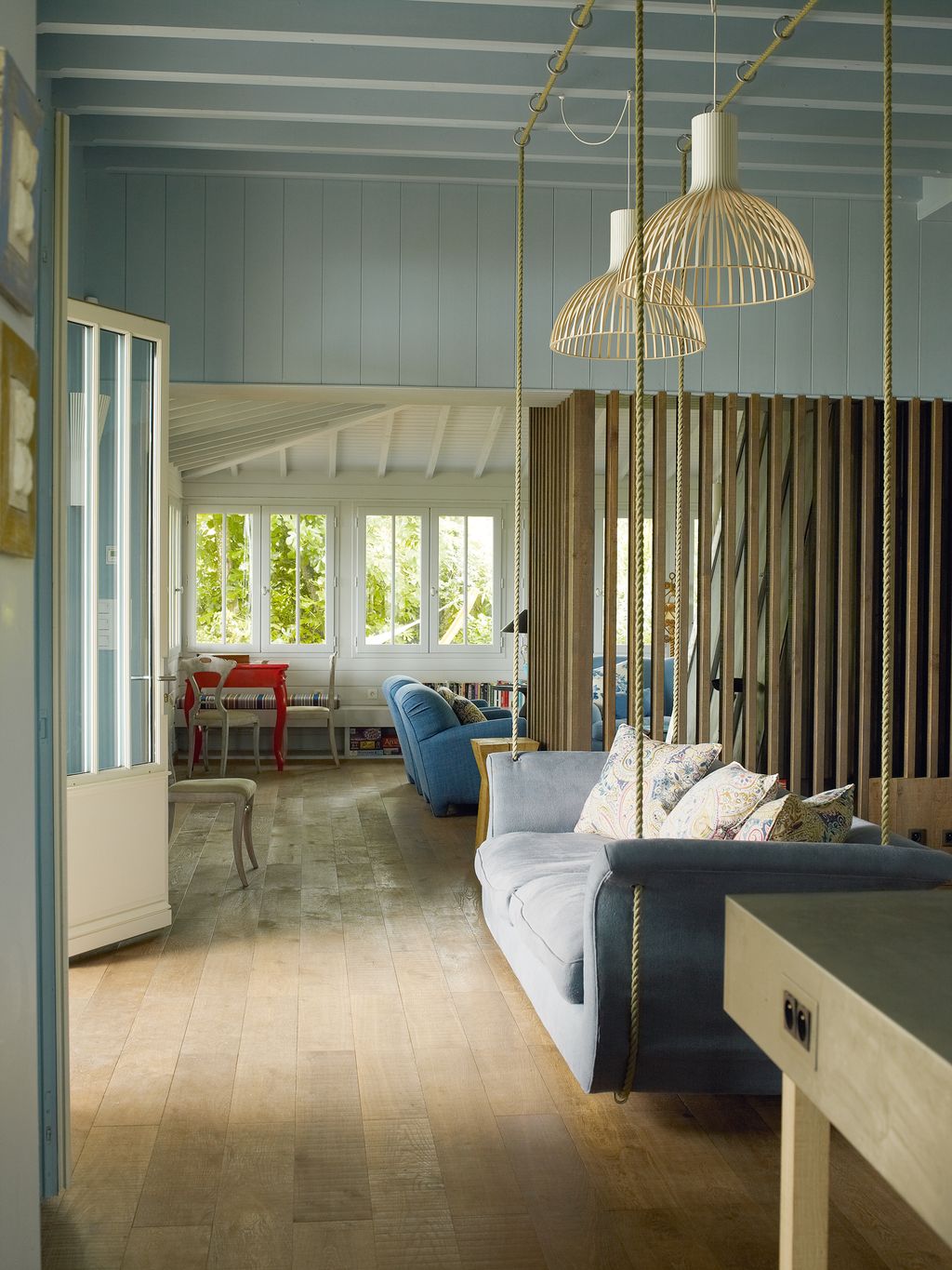 Jonathan Tuckey installed timber clairevoie screens that subtly separate the hall from the stairs and the sitting room .