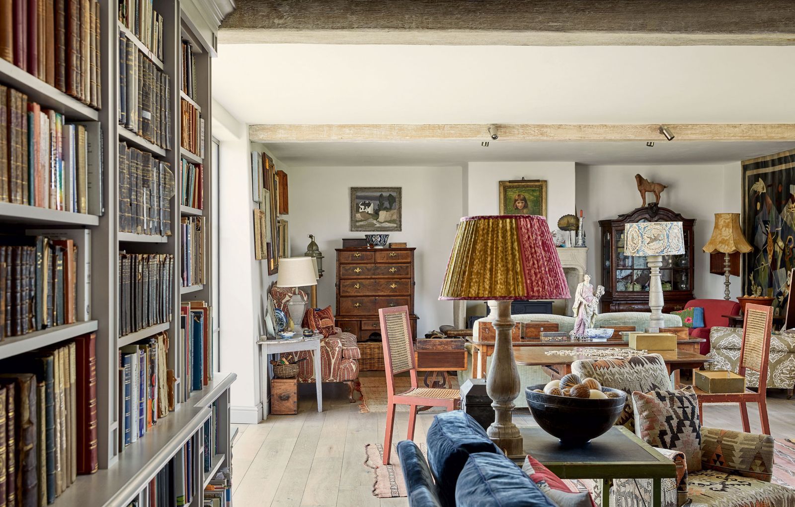 Image may contain Furniture Shelf Living Room Room Indoors Bookcase Interior Design Chair Lamp Table Lamp and Wood