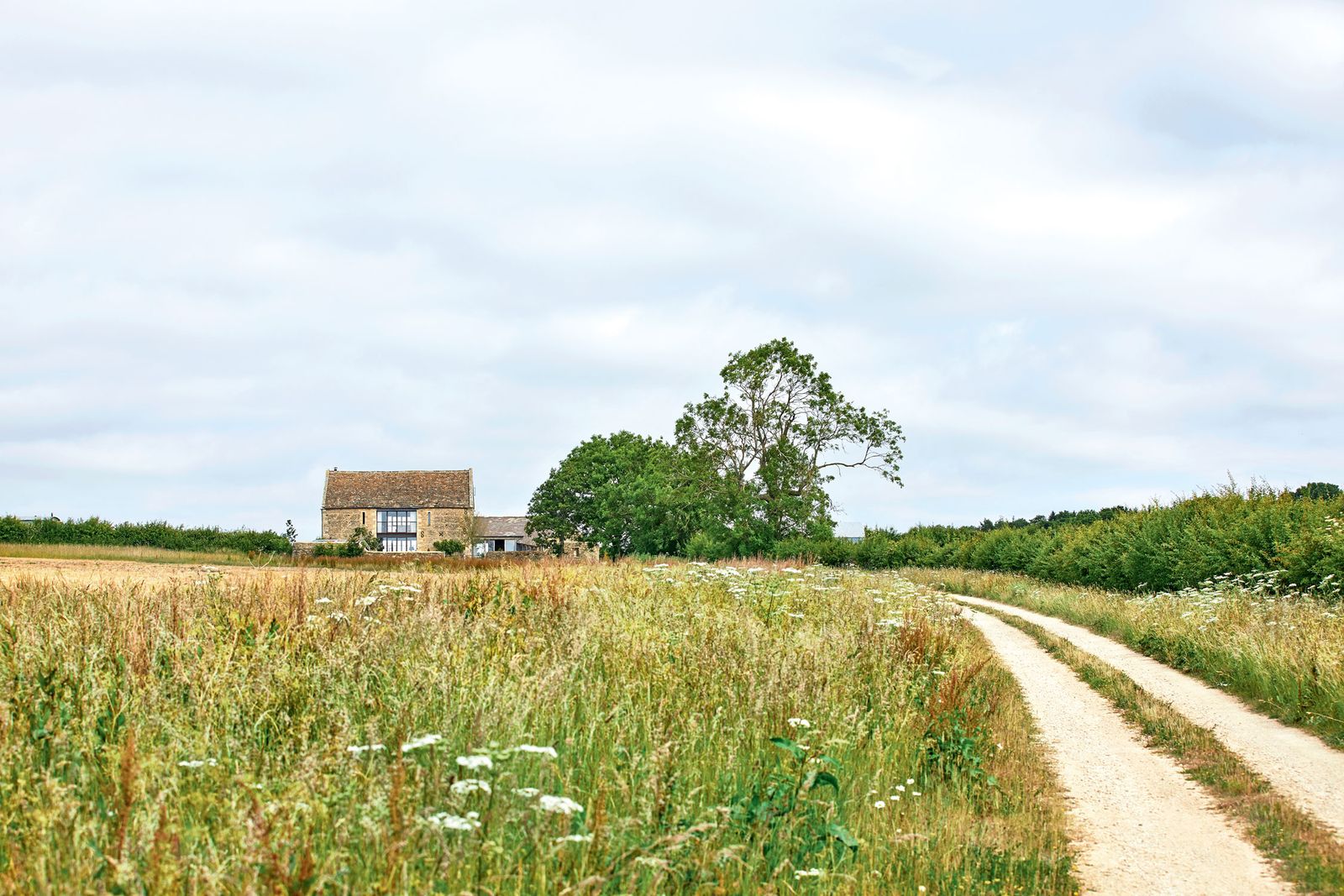A winding drive follows the line of an ancient Celtic trackway through wildflower meadows to the isolated hilltop barn....