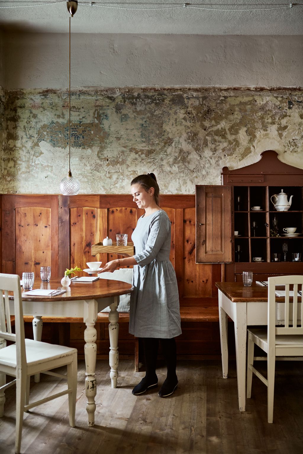 Image may contain Furniture Chair Wood Human Person Plywood Hardwood Dining Table Table Room Indoors and Flooring