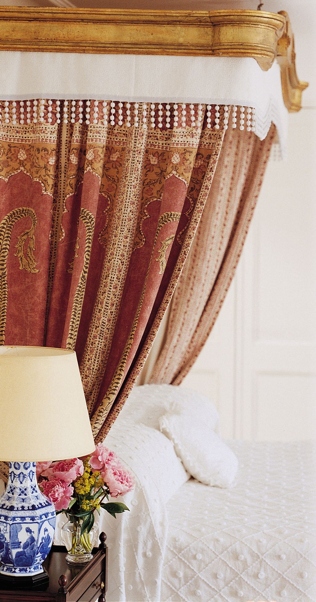 In the the main bedroom a posy of peonies adds to the countryhouse atmosphere.