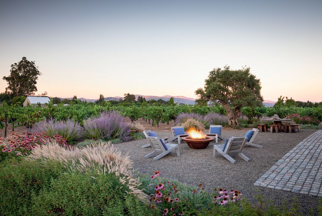Near the barn a firepit by Rodericks firm Surfacedesign built by Wyatt Studio is a focal point on the cobble and gravel...