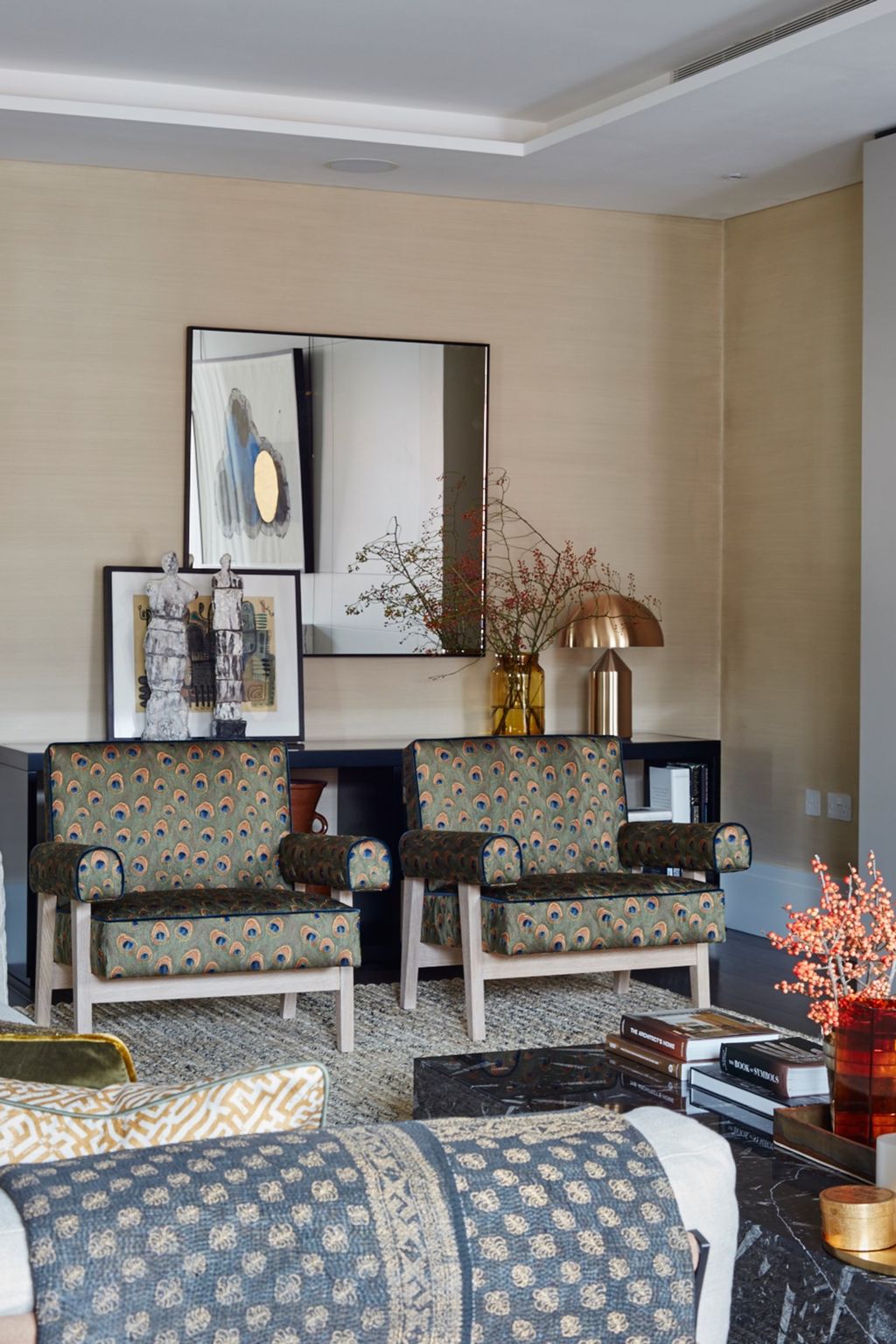 Statement armchairs upholstered in a beautiful peacock feather fabric make a statement in the living room.