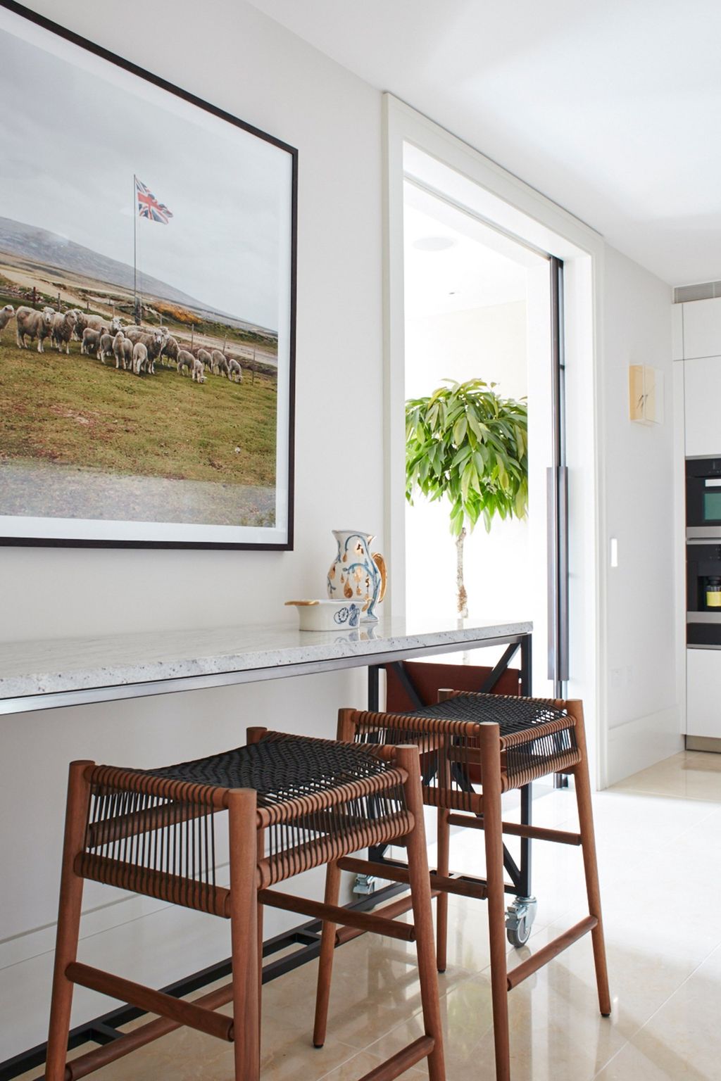 These high stools provide an informal dining or sitting area a houseplant glimpsed through the doorway adds warmth to...