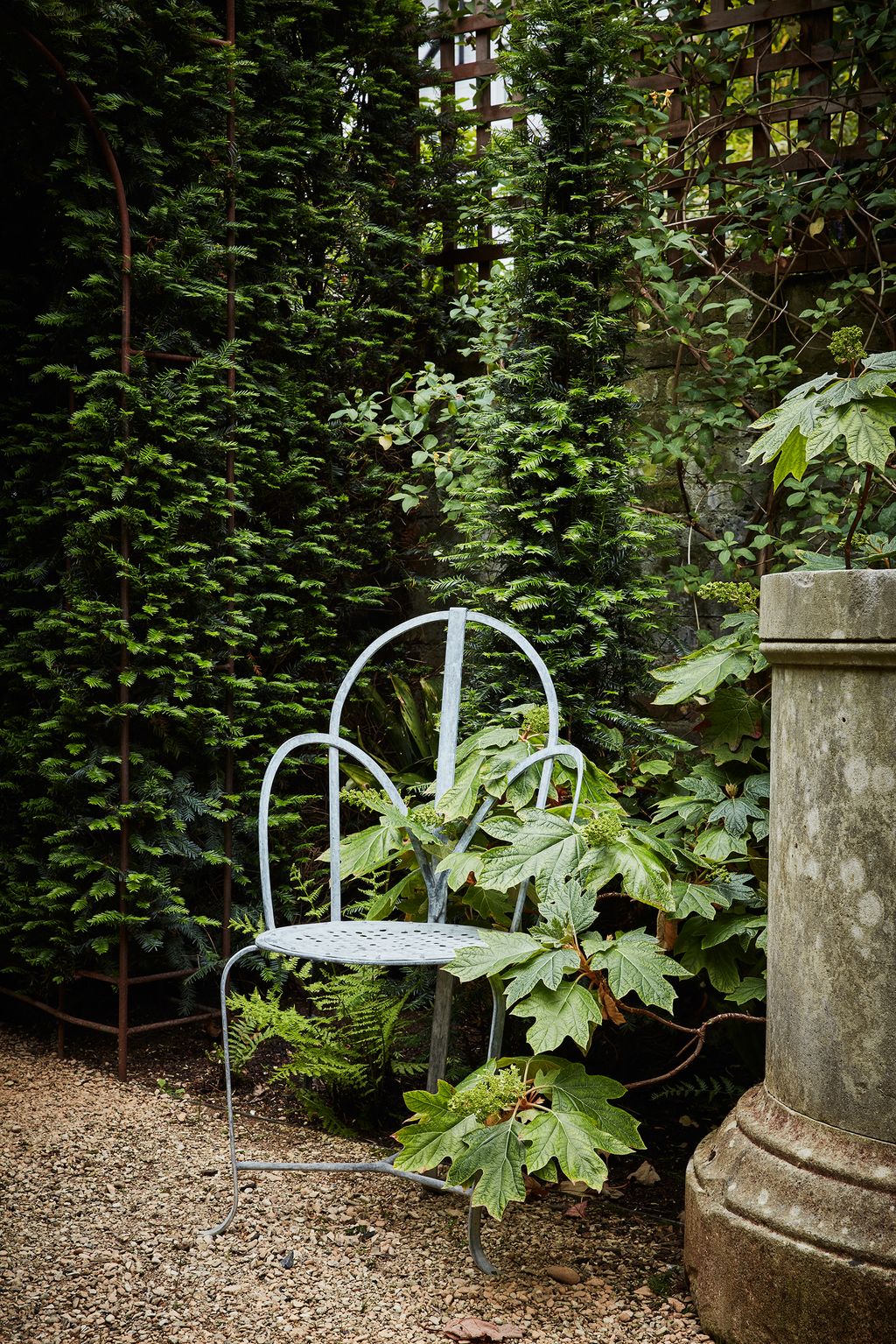Image may contain Furniture Plant Outdoors Chair Garden Vase Pottery Potted Plant Jar Arbour and Flagstone