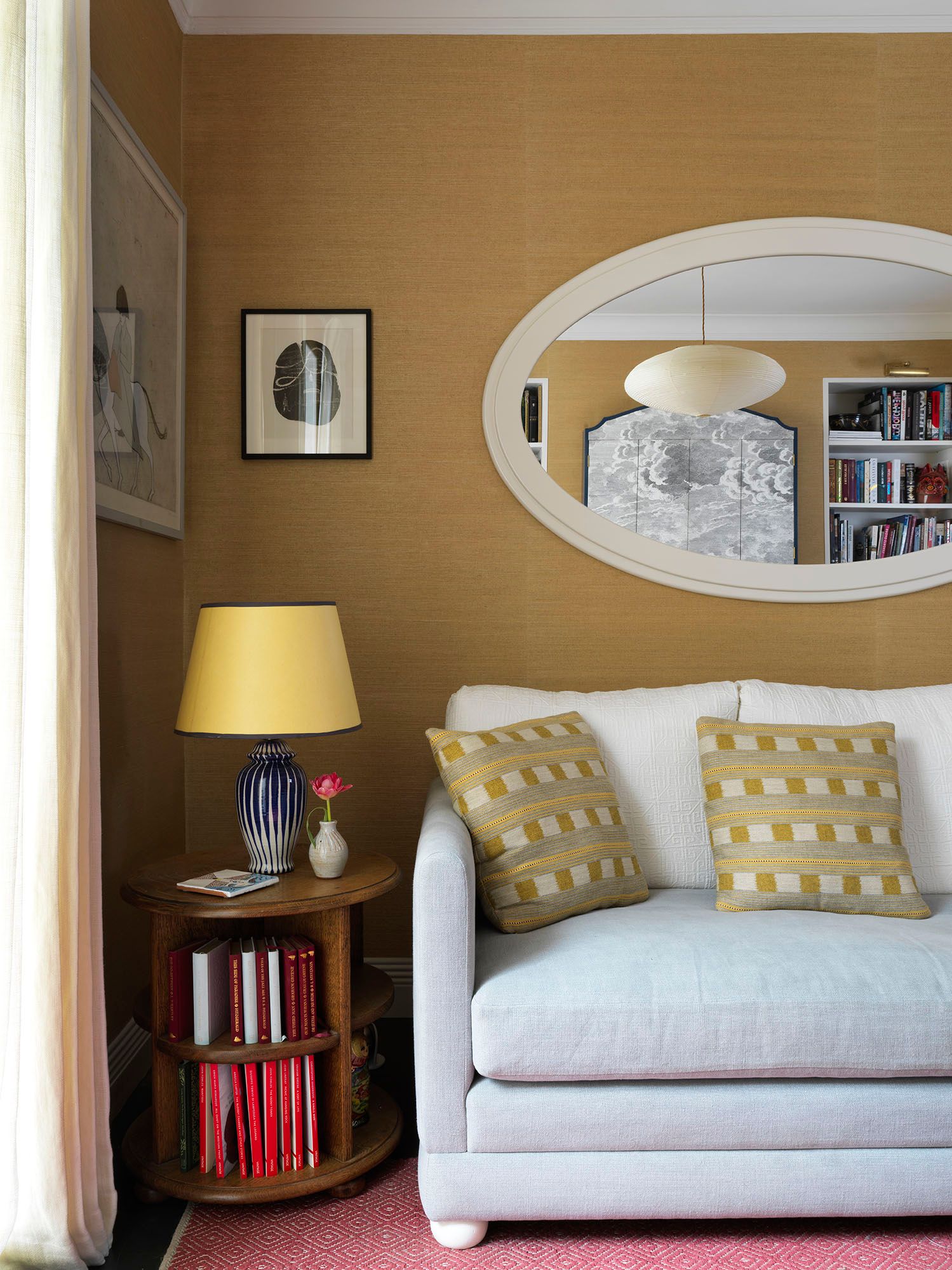 A pendant light from Heal's is reflected in the mirror in this tiny flat designed by Beata Heuman