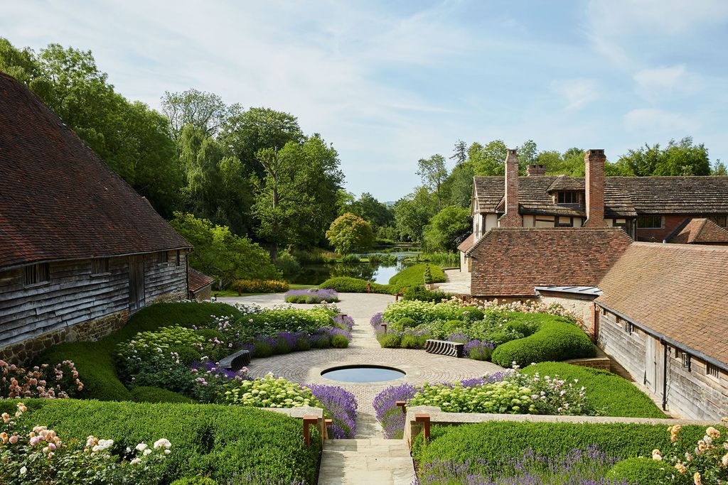 Image may contain Outdoors Grass Plant Garden Hedge Fence Water Building and Arbour