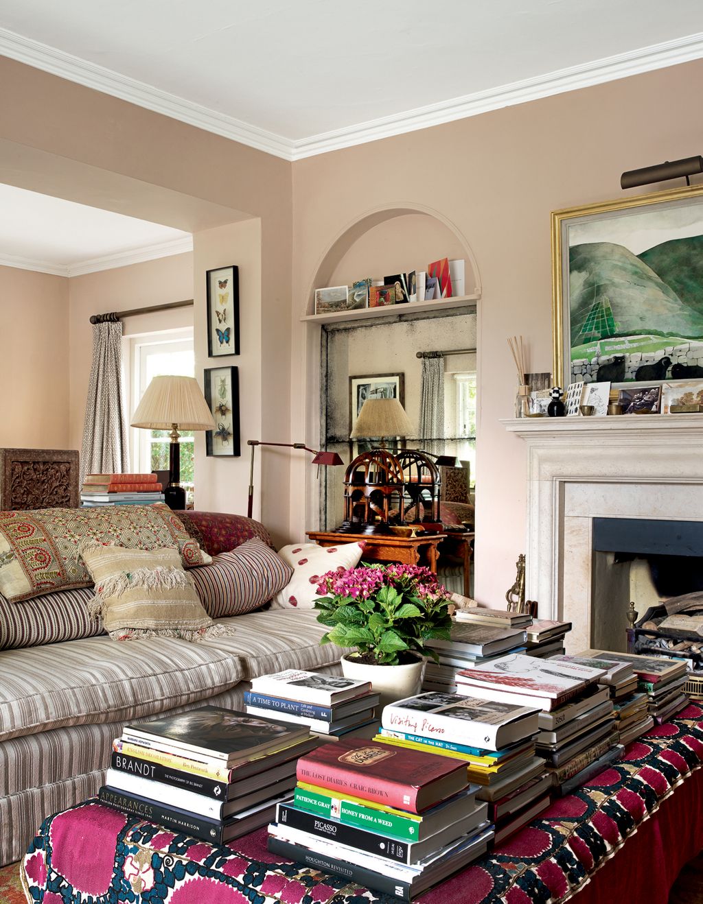 Walls painted in ‘Setting Plaster by Farrow  Ball provide a background for mounted insect specimens and artwork...