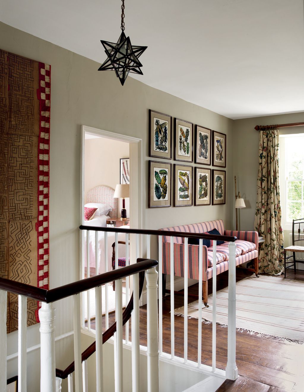 On the landing reproduction prints by EA Sguy  part of a series from c1928  hang above an antique French sofa with its...