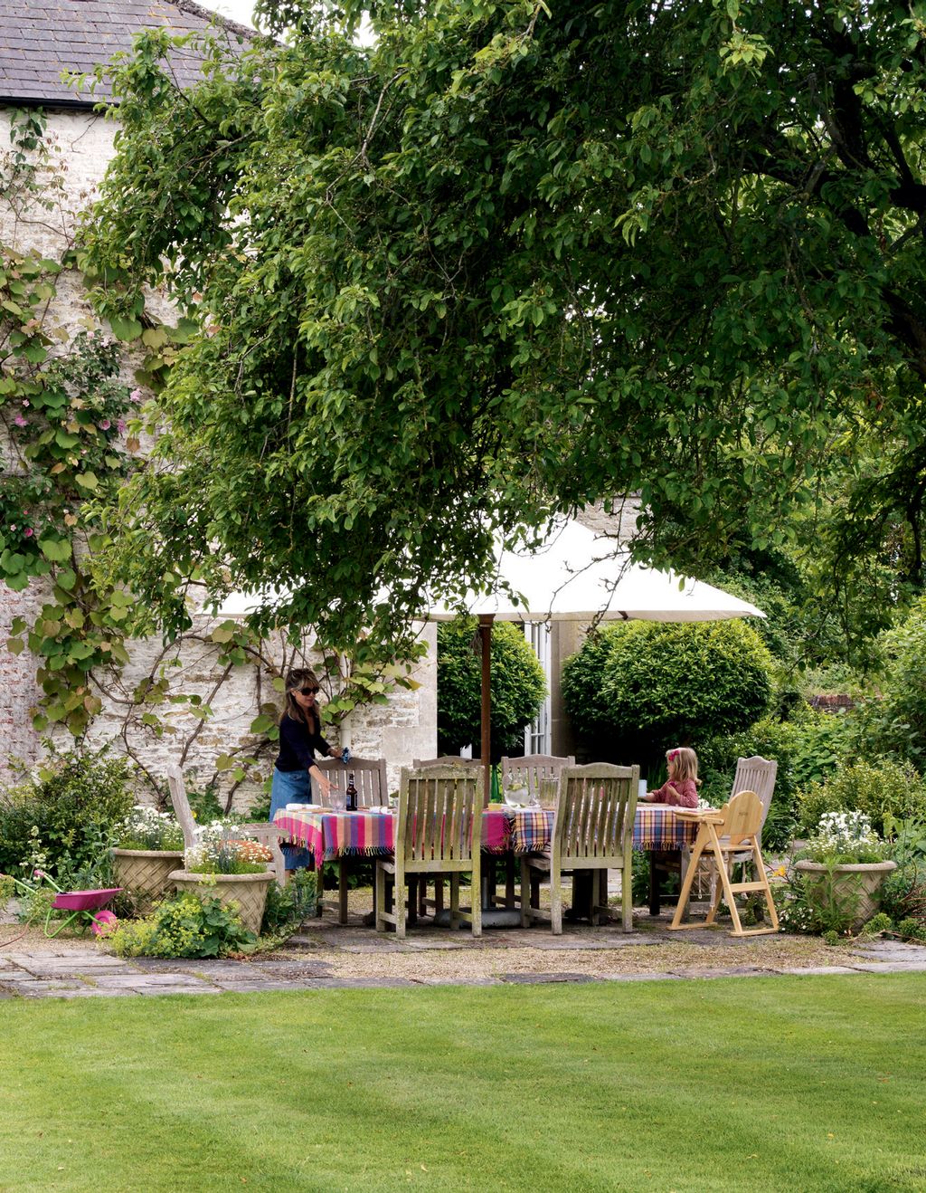 On the terrace colourful tablecloths brighten a wooden dining table and chairs by Gaze Burvill providing a relaxed...
