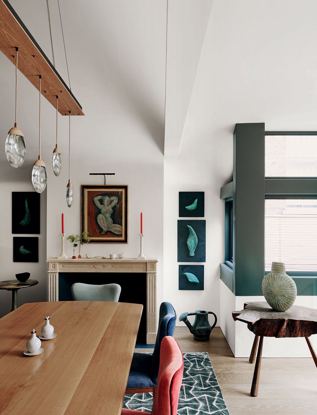 Ochres ‘Celestial Pebble lights hang above the table on which are oil and vinegar bottles by Lucie Rie. The bird...