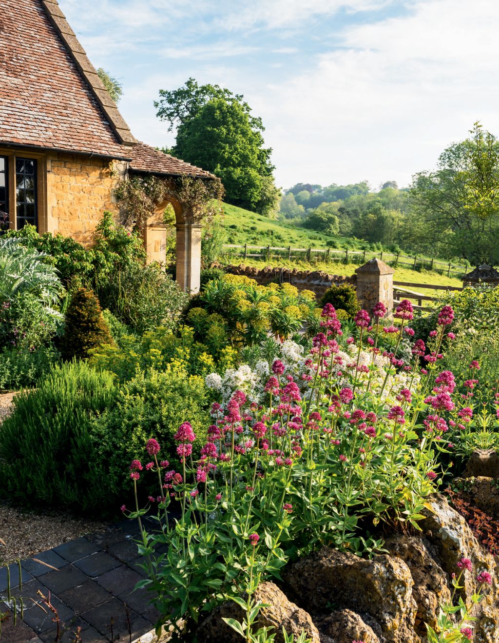 Image may contain Outdoors Garden House Cottage Housing Building Arbour Flagstone and Plant