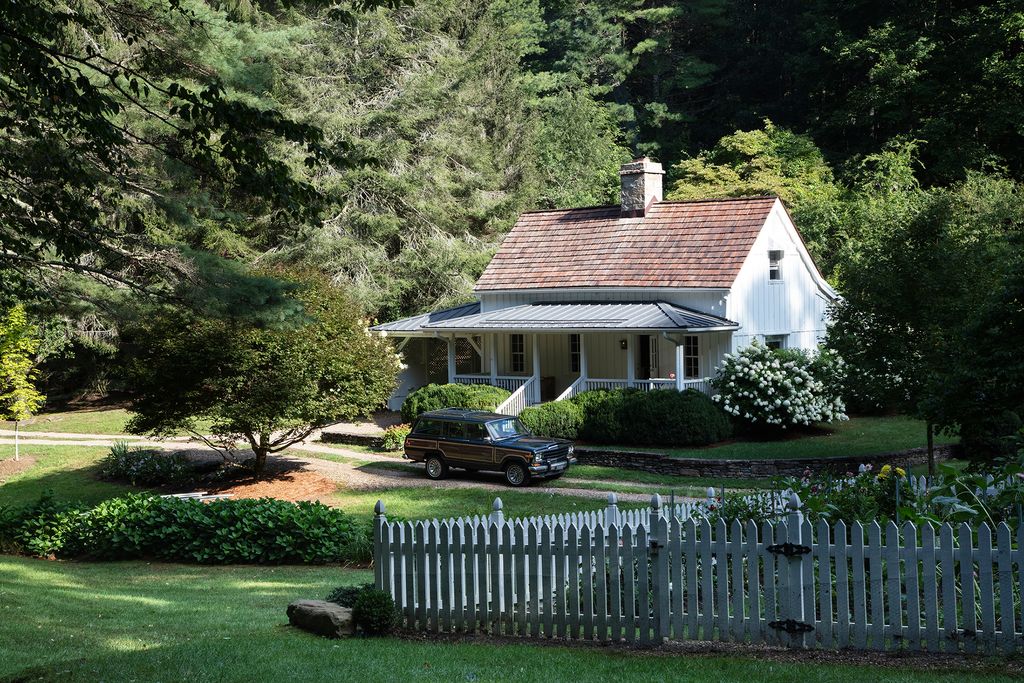 Image may contain Cottage Housing House Building Grass Plant Roof Fence Picket and Tree