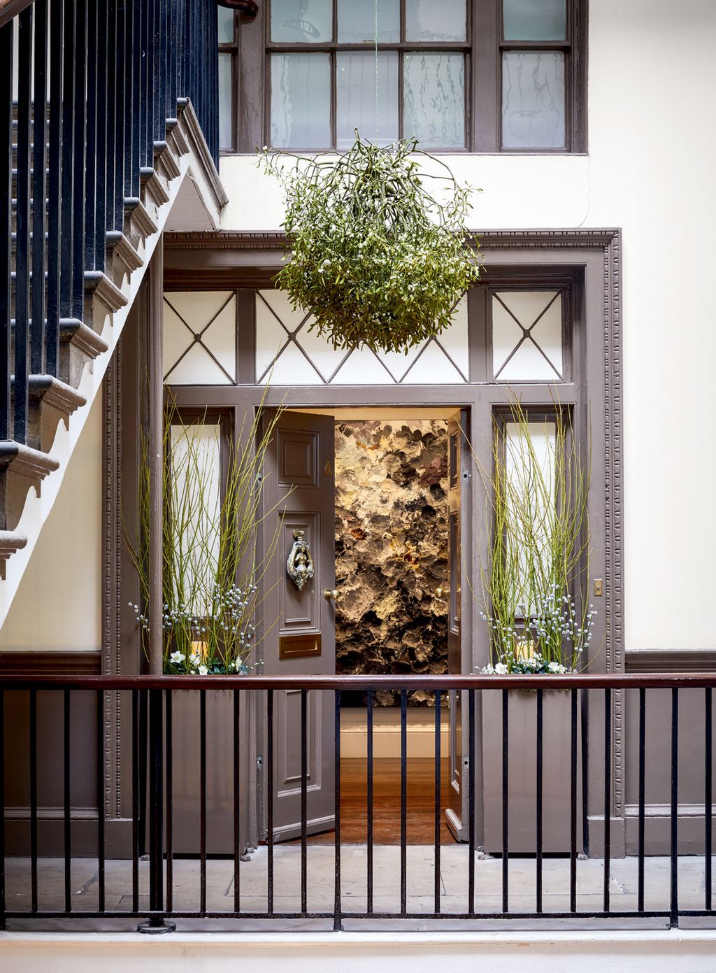 At Christmas garden designer Alexander Hoyle decorates the front door of Francis Sultana's Albany flat with mistletoe...