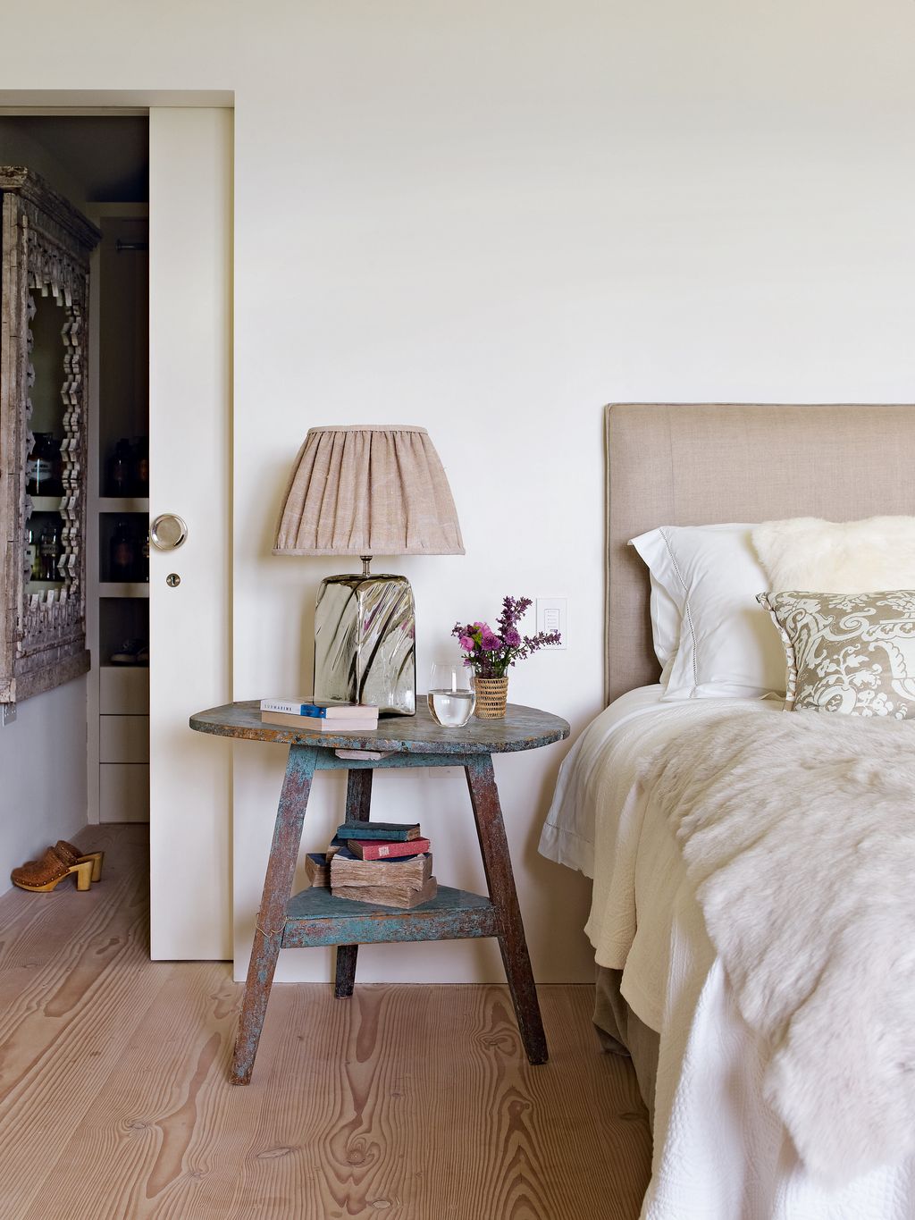 In the main bedroom the simple headboard is covered in Abbott  Boyd linen the bedside table came from John Bird Antiques...