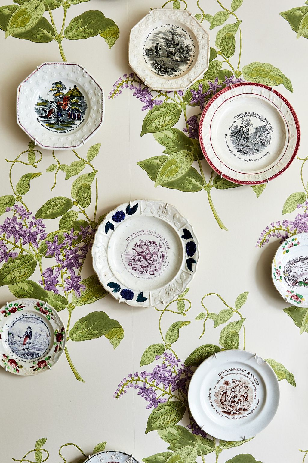 Nursery plates sourced from thesaleroom hang on one wall in the bathroom.