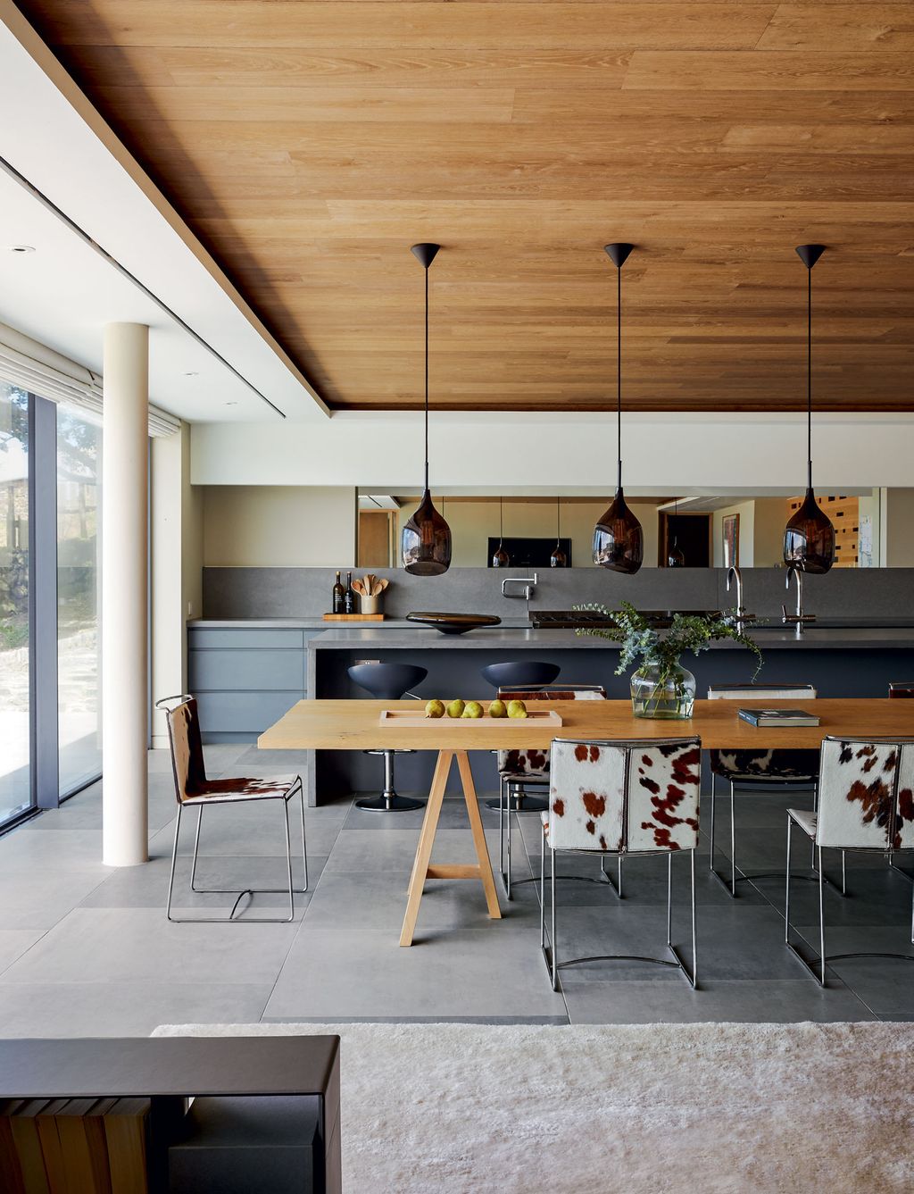 The oak trestle table is a bespoke piece and the ponyskincovered dining chairs are from Ligne Roset.