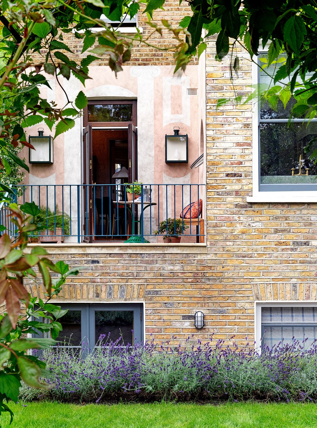 Our terrace as seen from the garden house. The open doors look into the breakfast room. The wall lights are my studios...