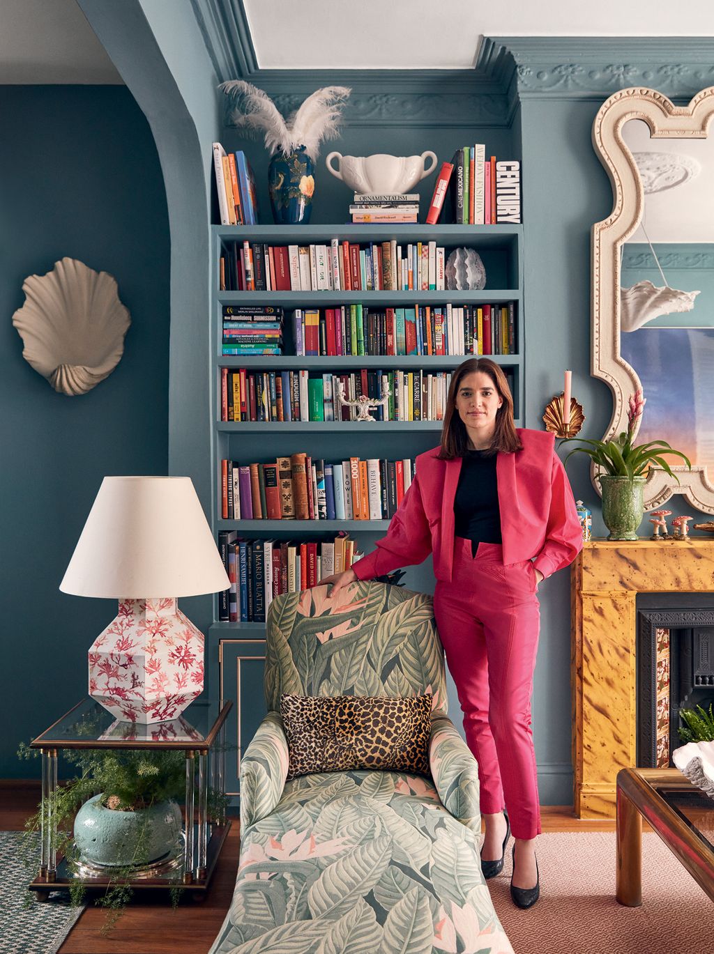 Image may contain Furniture Human Person Lamp Bookcase Living Room Room Indoors Shelf and Couch