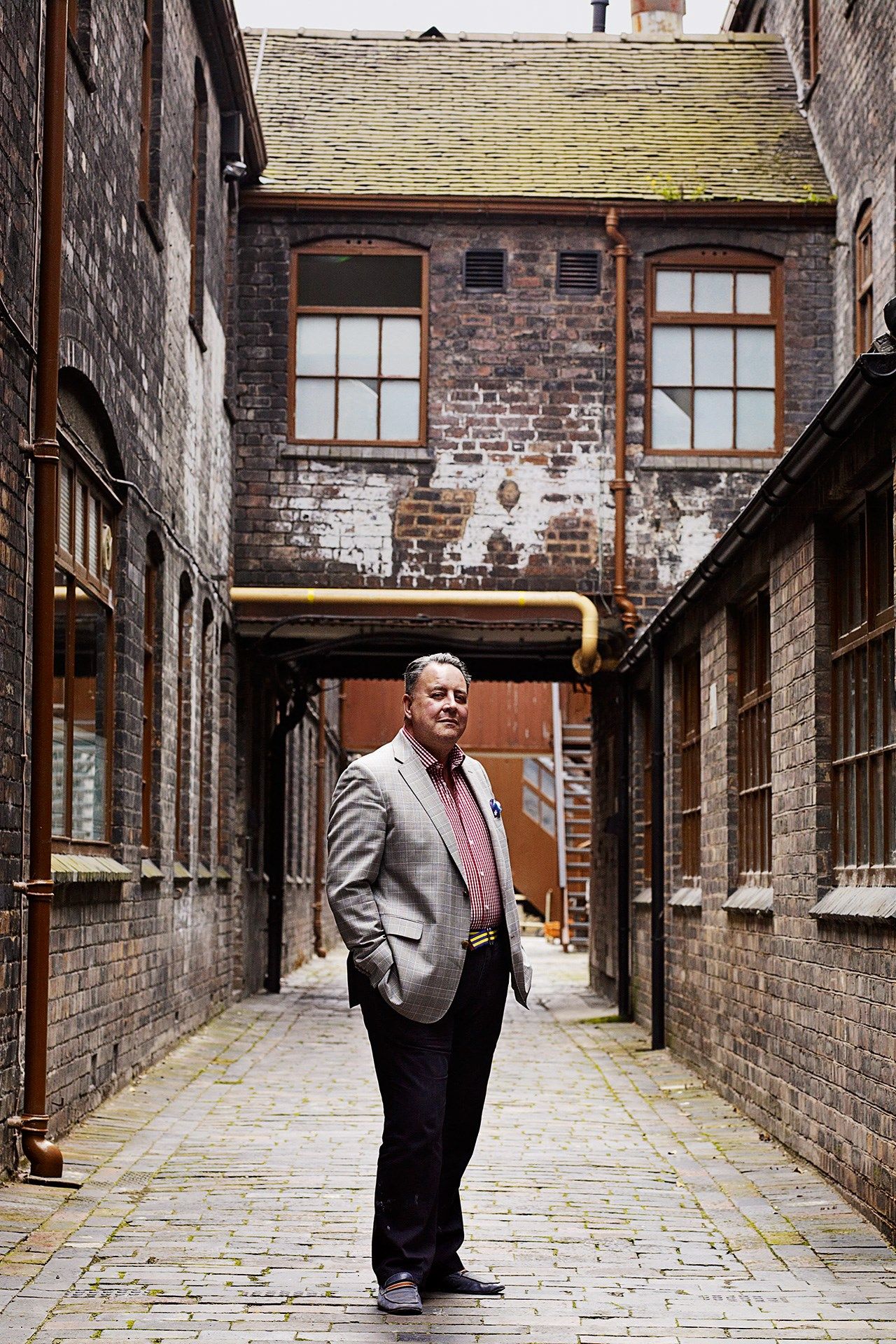 Image may contain Path Walkway Clothing Apparel Corridor Flagstone Shoe Footwear Human Person Brick and Coat