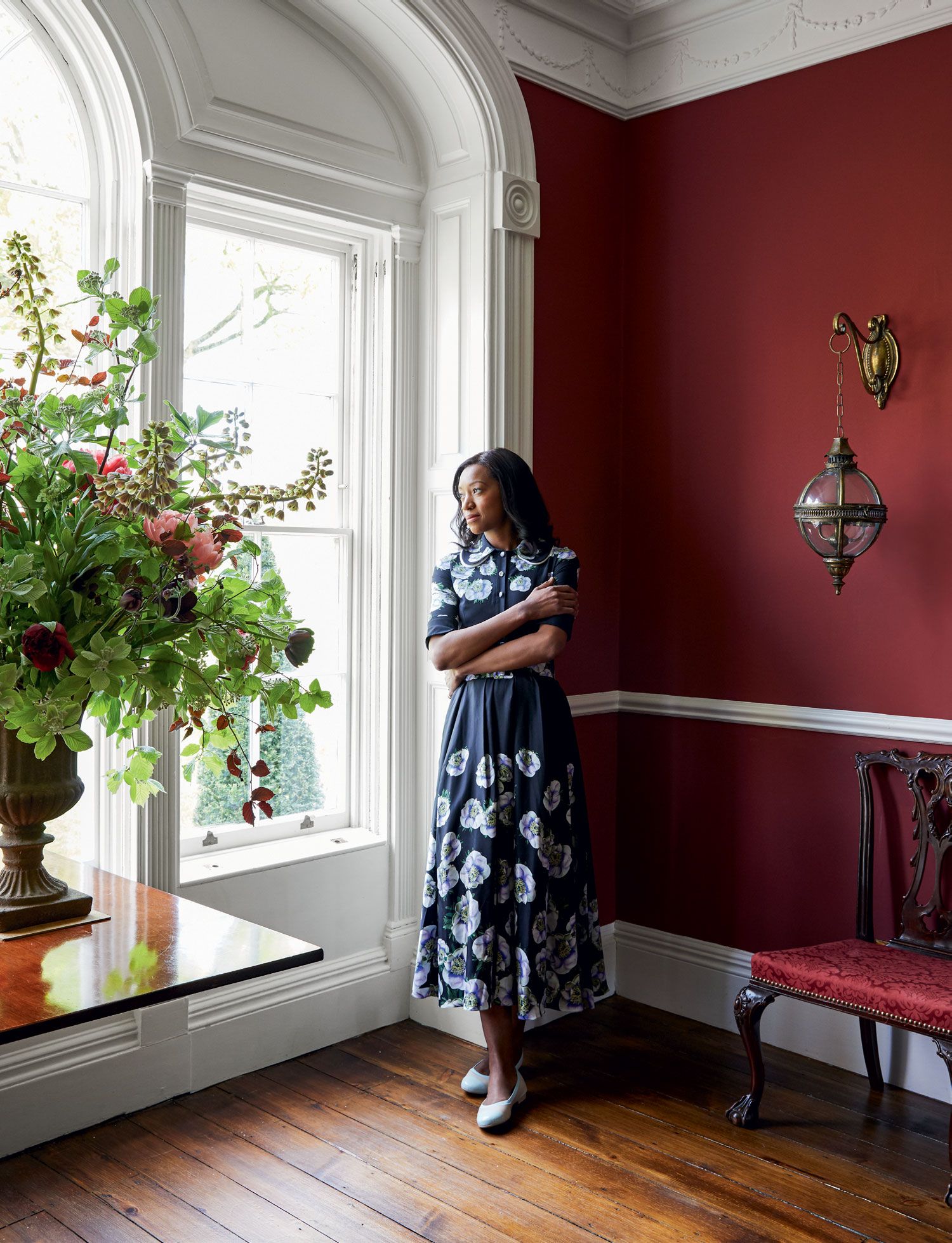 Image may contain Indoors Interior Design Human Person Living Room Room Furniture Plant Wood Flooring and Flower