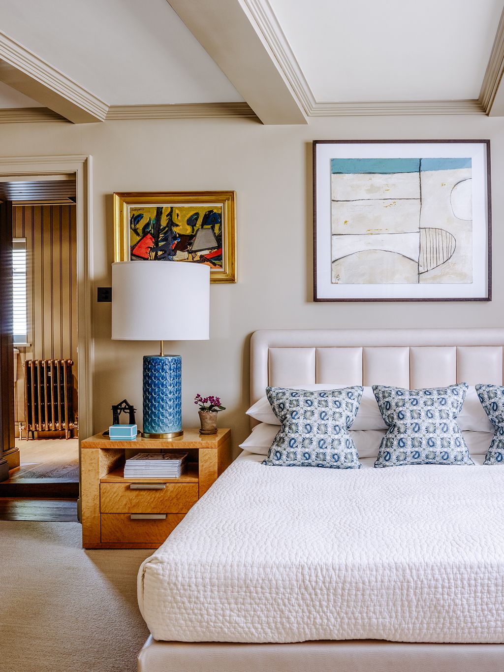 A lamp from Visual Comfort sits on a custommade lacquered sycamore bedside table. The headboard was designed by Stephen...